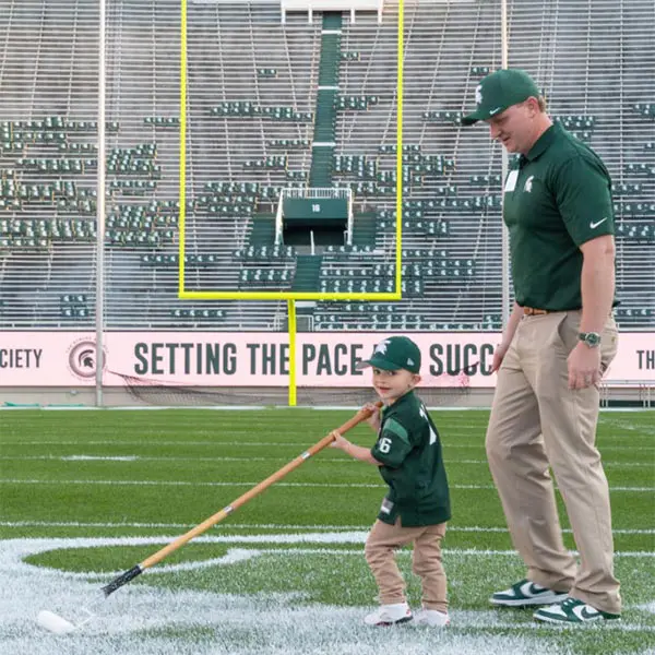 two volunteers helping paint the field